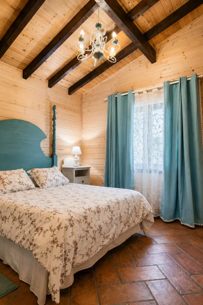 Dormitorio con cama de matrimonio, vigas de madera y cortinas verdes