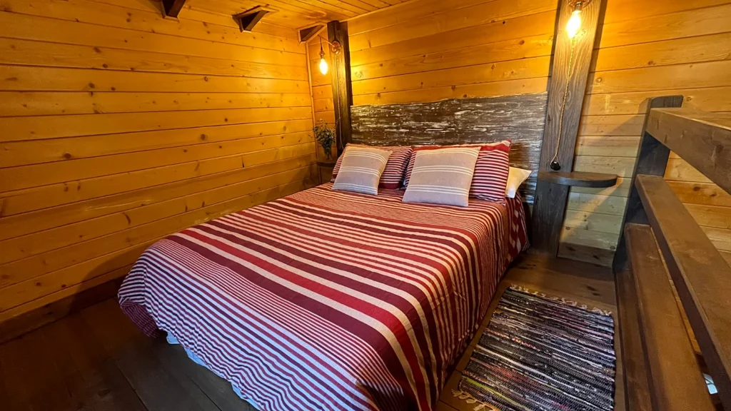Buhardilla de madera de la habitación Arbequina con cama de matrimonio