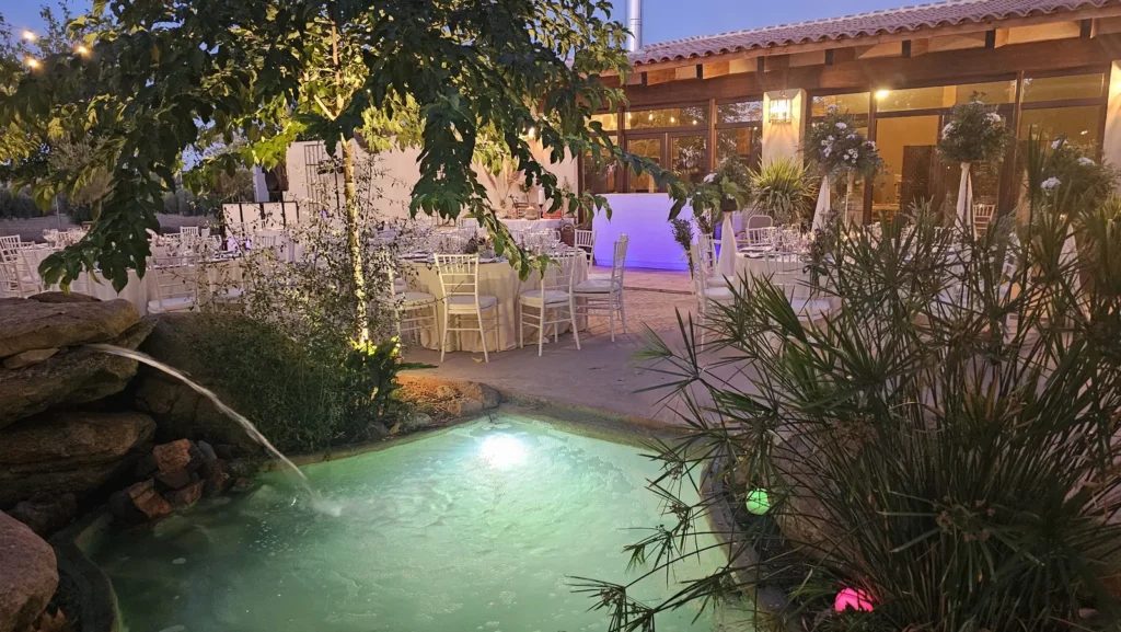 Mesa de boda iluminada junto a la piscina de Los Castillos