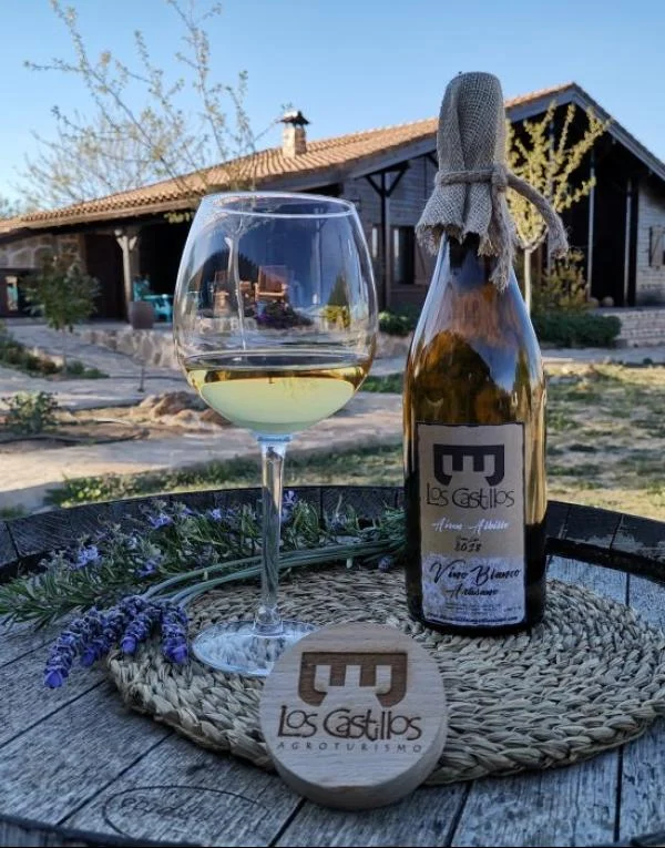 Botella de vino artesano Los Castillos junto a una copa